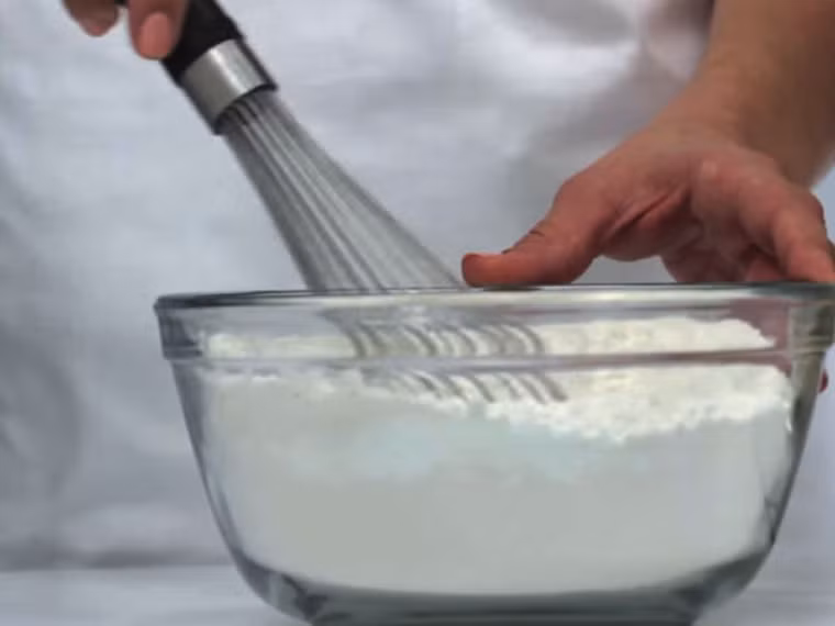 Lần lượt cho thêm chút vani, bột vỏ chanh và rượu rum vào đảo đều.