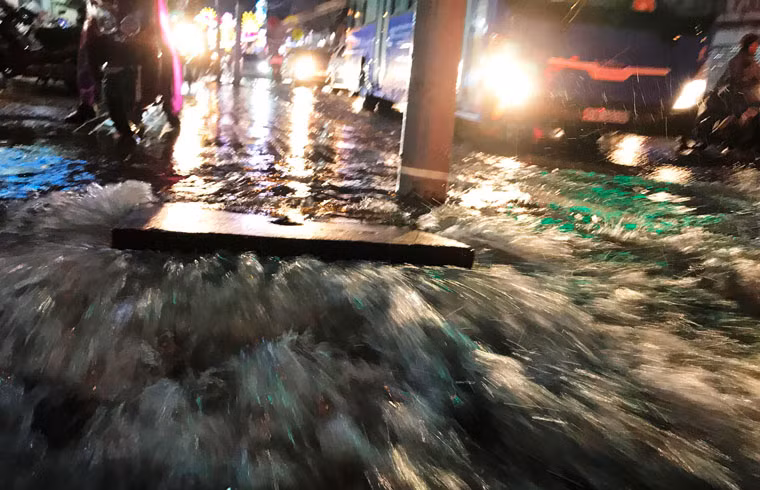 Nước mưa từ khu vực cống trên đường Võ Văn Ngân, quận Thủ Đức cuồn cuộn như muốn cuốn trôi tất cả trên đường.