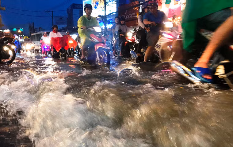 Nước mưa tuôn xối xả trên đường phố khiến người tham gia giao thông 1 phen khốn đốn.