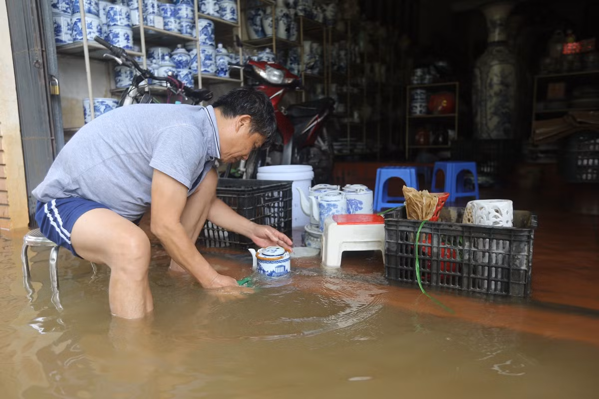 "Nước bắt đầu ngập và dâng nhanh từ đêm ngày 11/9, nhà tôi nước ngập vào đầu gối, các sản phẩm đồ gốm phải gom, di chuyển thật nhanh. Đến khi trời hết mưa thì nước không dâng nữa, đến nay rút được một ít nhưng không đáng kể, tôi tranh thủ rửa những đồ bị ngấm nước", ông Minh (xã Bát Tràng) chia sẻ.