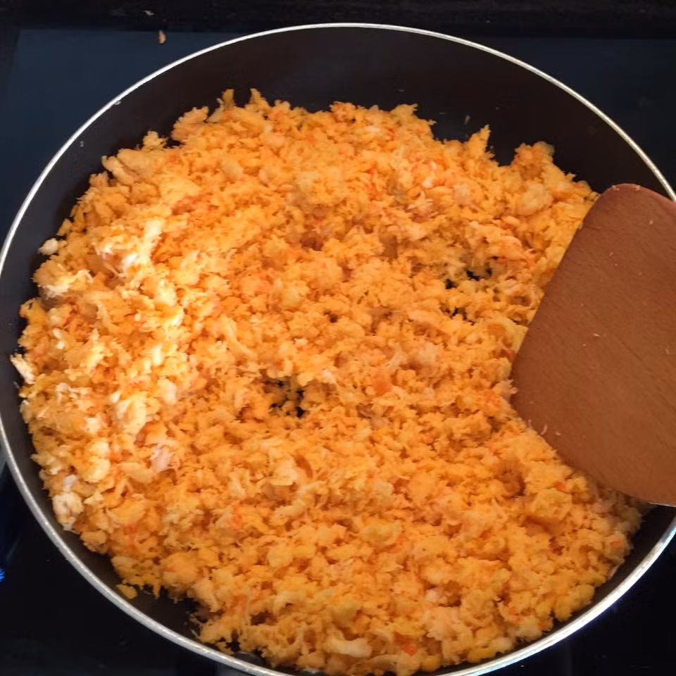 Bước 3: Khi nào tôm bông lên thì cho thêm dầu gấc để có màu đỏ đều đẹp, ngâm khoảng 20 phút. 