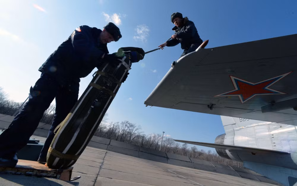 Các cán bộ kỹ thuật đang nạp bộ dù hãm tốc vào đuôi máy bay chuẩn bị cho cuộc tập trận. Nguồn ảnh: Sputnik