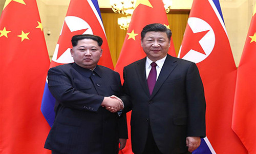 Lãnh đạo Triều Tiên Kim Jong-un (trái) bắt tay Chủ tịch Trung Quốc Tập Cận Bình trong cuộc gặp tại thủ đô Bắc Kinh. Ảnh: THX.
