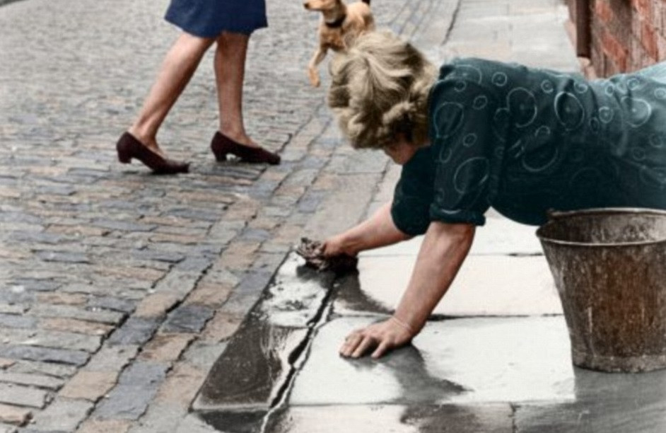 Người phụ nữ lau dọn lối đi trước nhà ở Birkenhead, Merseyside, năm 1944.