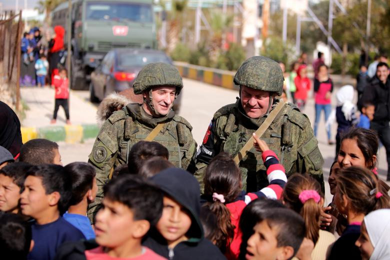 Những người lính Nga trò chuyện với các em nhỏ Syria tại Wafideen Camp hôm 28/2.