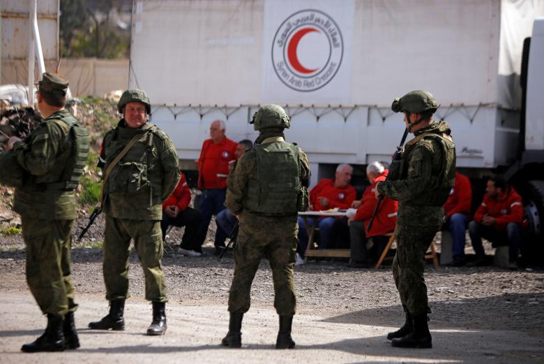 Binh sĩ Nga đảm bảo an toàn cho một chiếc xe chở hàng viện trợ nhân đạo tại chốt kiểm soát gần Wafideen Camp ở Damascus ngày 5/3.