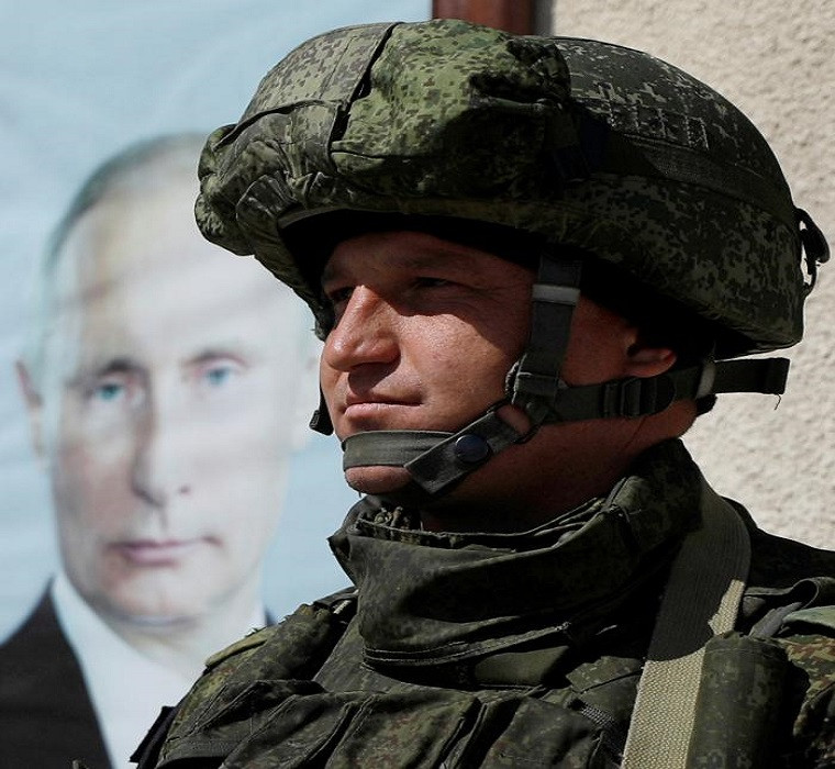 Một lính Nga đứng gần bức chân dung Tổng thống Nga Vladimir Putin được treo trên tường tại Wafideen Camp ngày 2/3.