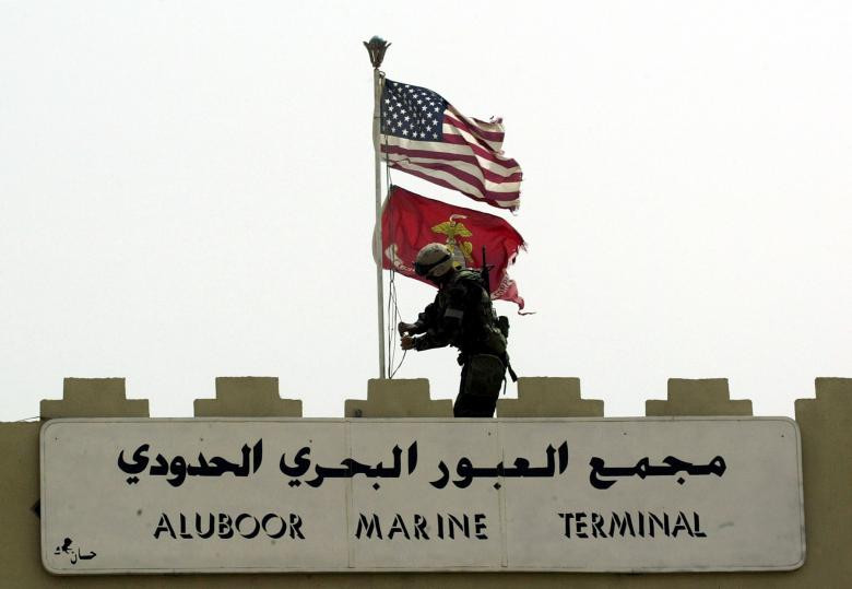 Một lính Thủy quân lục chiến Mỹ vừa thay thế lá cờ Iraq tại lối vào cảng chính Umm Qasr, Iraq, ngày 21/3/2003.