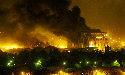 Tuy nhiên, sự sụp đổ của chính quyền Hussein cũng là lúc đất nước Iraq chìm vào trong hỗn loạn, bạo lực và bất ổn, cùng với đó là sự trổi dậy của các nhóm khủng bố cực đoan mà đỉnh cao là Nhà nước Hồi giáo tự xưng IS. Đất nước Iraq tiếp tục chìm trong chiến sự, bất ổn suốt hơn 10 năm qua. Ảnh: Thủ đô Baghdad rung chuyển sau một vụ không kích ngày 21/3/2003.