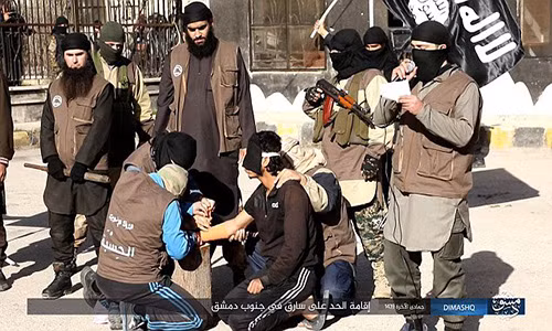 Các tay súng IS chuẩn bị chặt tay một người đàn ông bị cáo buộc là kẻ trộm. Ảnh: Daily Mail.