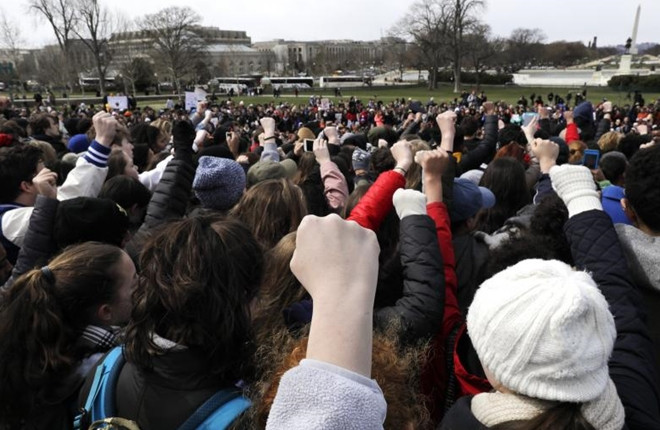 Những học sinh ở Washington D.C thể hiện sự đoàn kết và giơ tay cao lên trời.