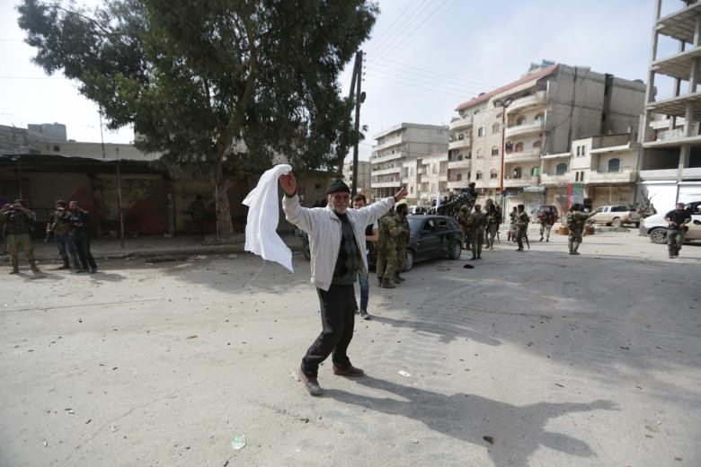 Người đàn ông vẫy cờ trắng sau khi lực lượng Thổ Nhĩ Kỳ được triển khai tới khu vực này hôm 18/3. Ảnh: Reuters.