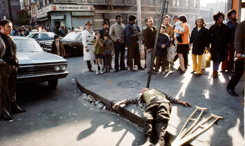 Những người đi đường đứng nhìn một người đàn ông bị ngất trên góc phố 172 ở quận Bronx.