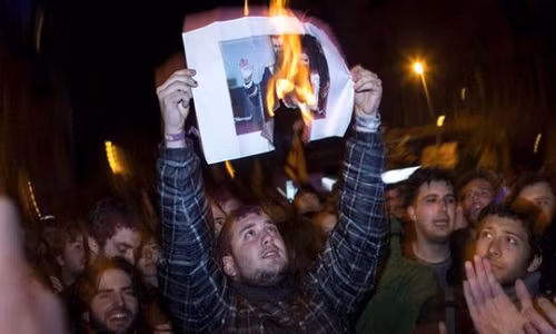 Người biểu tình đốt hình Vua Felipe. Ảnh: EPA.