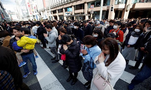 Mọi người dành phút mặc niệm tưởng nhớ các nạn nhân vụ động đất-sóng thần, tại quận Ginza, thủ đô Tokyo, Nhật Bản, ngày 11/3. Ảnh: Reuters.