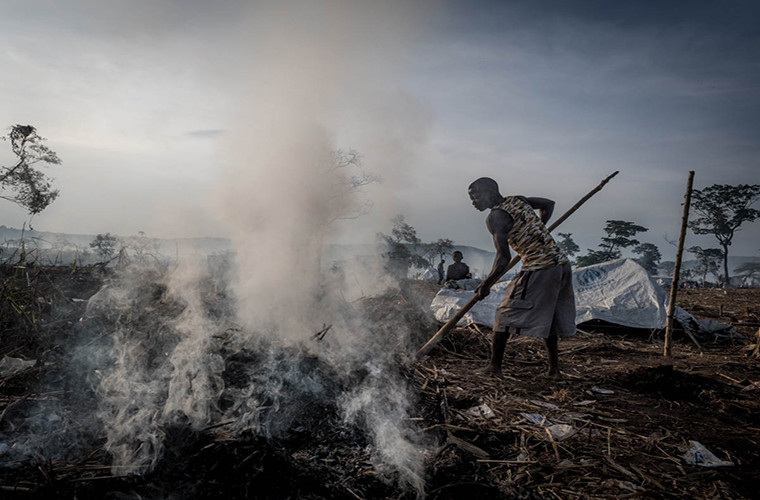 Người dân đốt cỏ khô để lấy chỗ dựng trại cho những người tị nạn mới đến từ Công-gô.