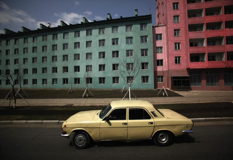 Chiếc ô tô đi qua tòa nhà chung cư ở Bình Nhưỡng ngày 11/4/2012.