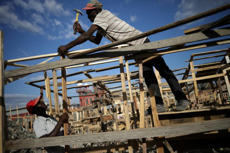 Các công nhân đang xây dựng một khu chợ bị phá hủy trong vụ hỏa hoạn tuần trước đó ở Port-au-Prince hôm 21/2.
