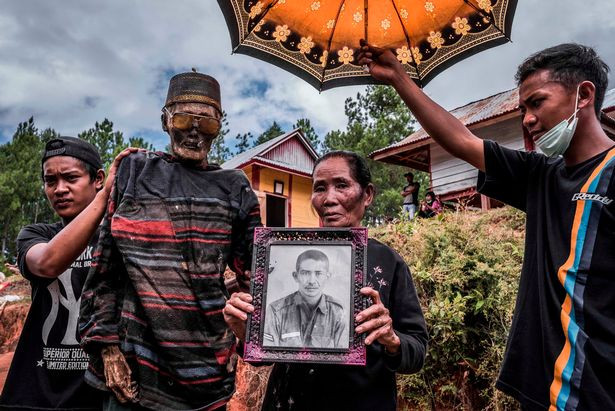 Các thành viên trong gia đình chụp ảnh với người thân quá cố.