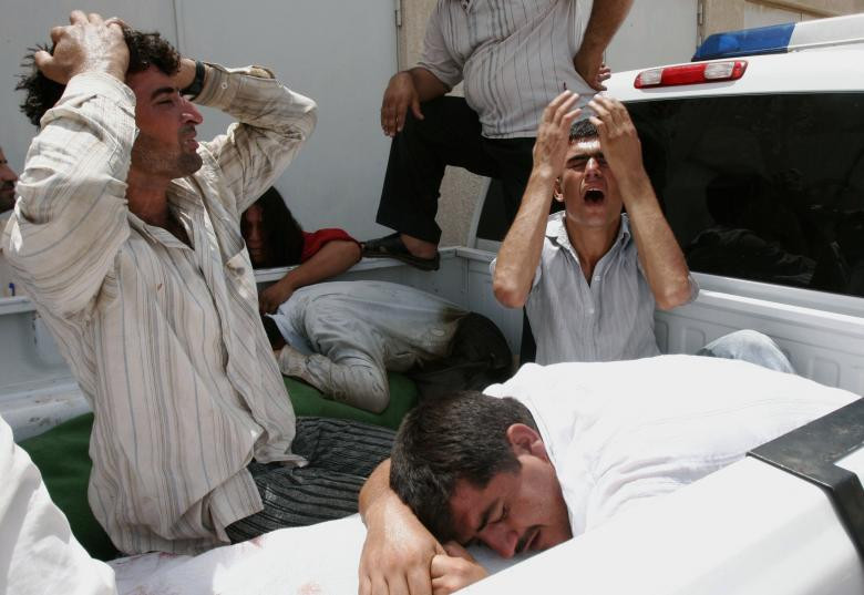 Những người thân đau buồn khi thi thể của các cảnh sát được đưa tới nhà xác của bệnh viện ở Kirkuk ngày 12/8/2007.