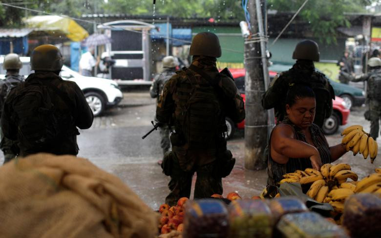 Các binh sĩ Brazil đứng trước sạp hàng bán hoa quả tại khu ổ chuột Vila Kennedy.