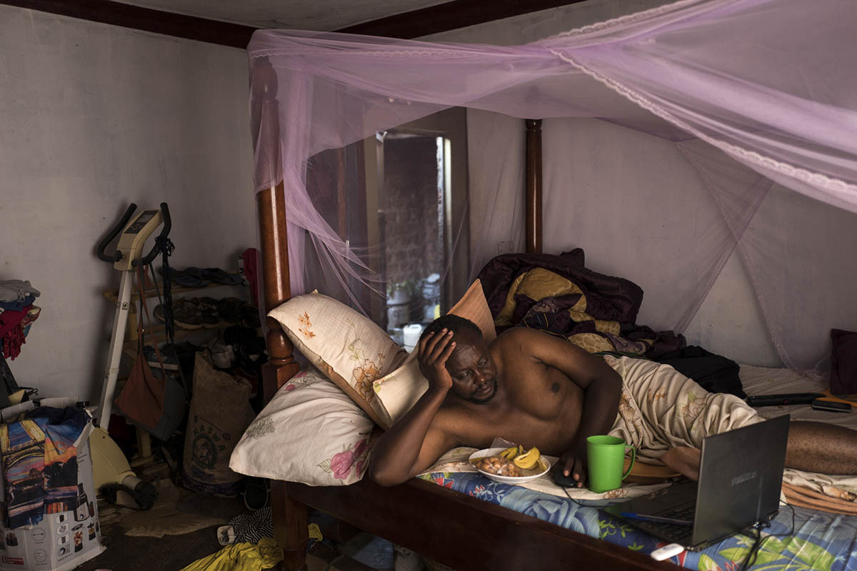 Nhà sản xuất phim Isaac Nabwana, 45 tuổi, vừa ăn sáng vừa xem video trên máy tính.