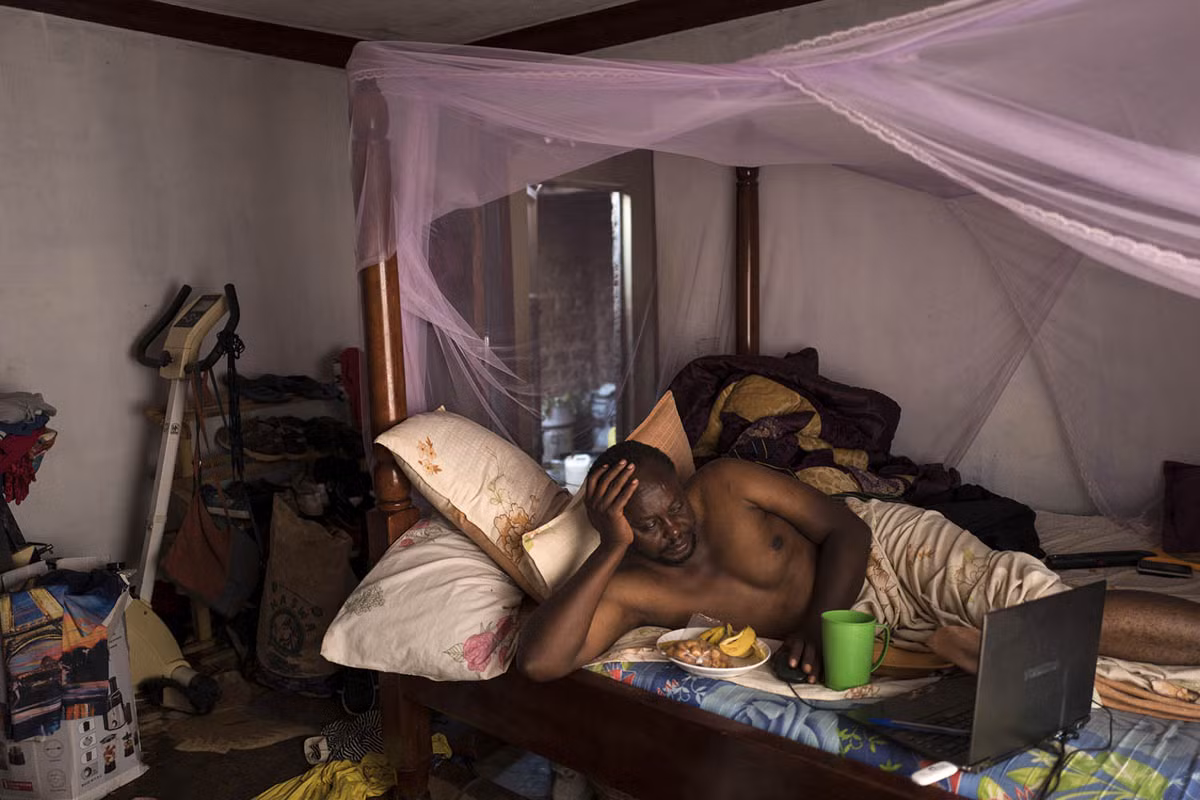 Nhà sản xuất phim Isaac Nabwana, 45 tuổi, vừa ăn sáng vừa xem video trên máy tính.