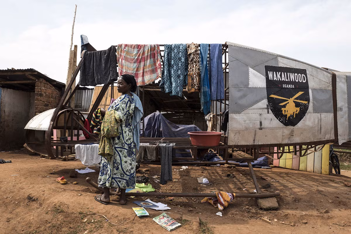 Gertrude Nabachwa, 63 tuổi, mẹ vợ của Nabwana phơi quần áo trên chiếc trực thăng giả trong sân của khu ổ chuột Wakaliga.