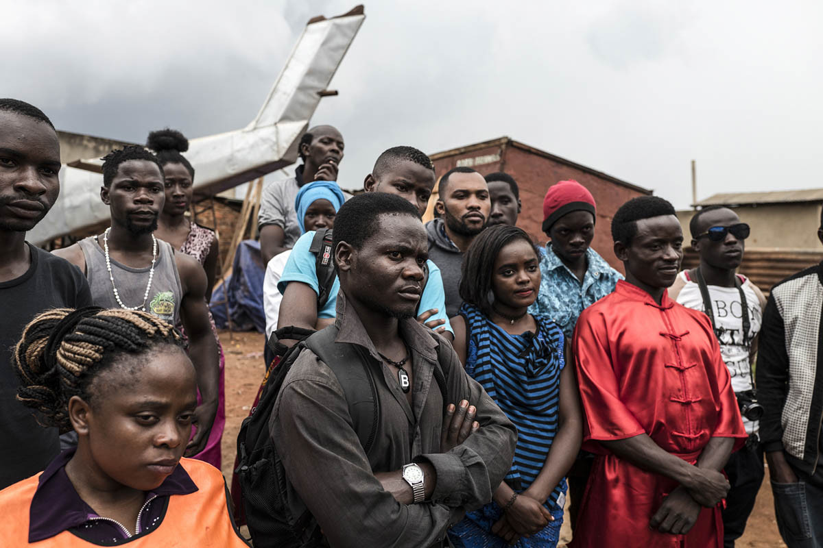 Các diễn viên đứng quan sát trước một cảnh bắn súng trong bộ phim Bruce U của Nabwana.