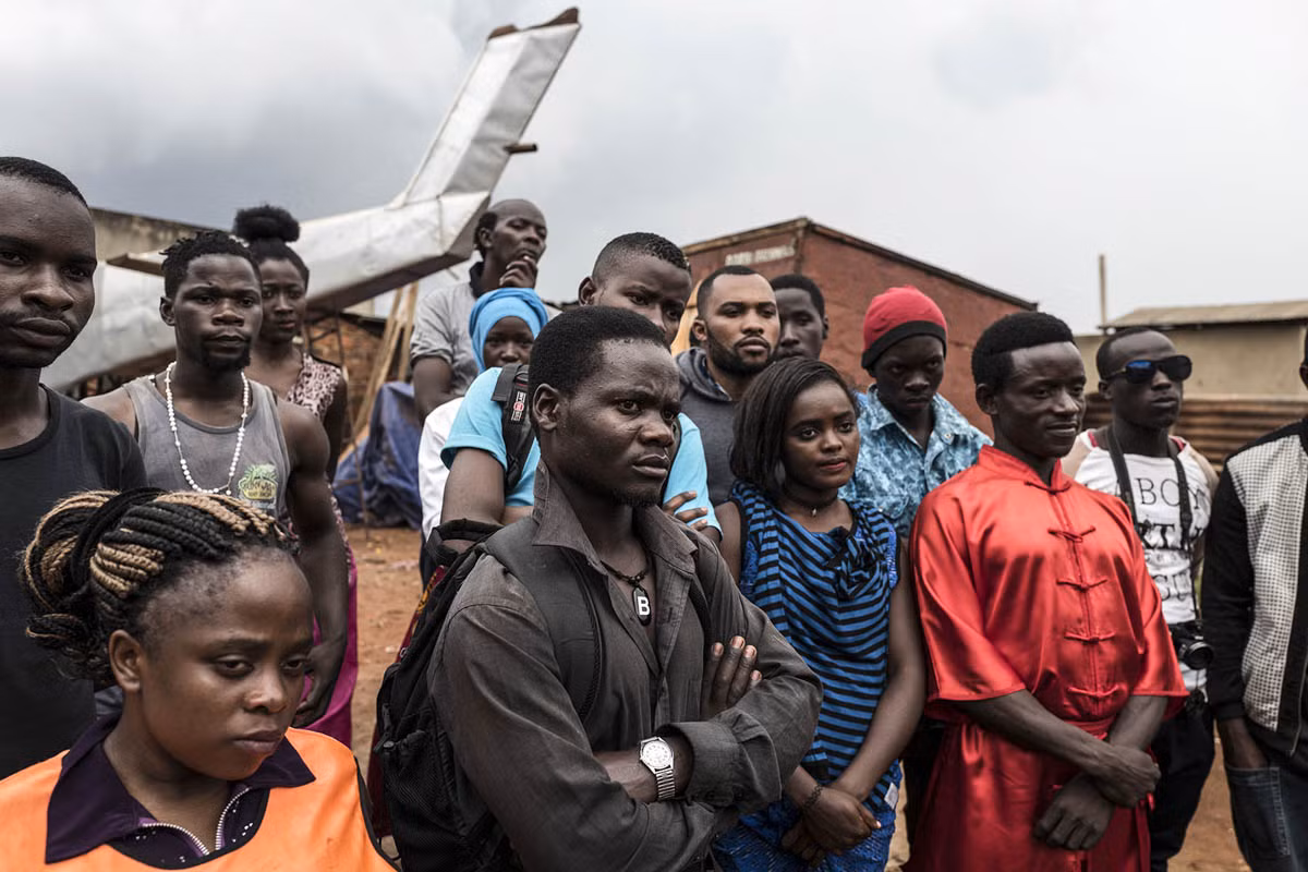 Các diễn viên đứng quan sát trước một cảnh bắn súng trong bộ phim Bruce U của Nabwana.