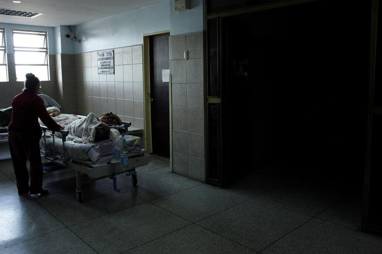 Một bệnh nhân nằm chờ ở hành lang bệnh viện San Cristobal do mất điện khiến thang máy không hoạt động hôm 14/3. Ảnh: Reuters.