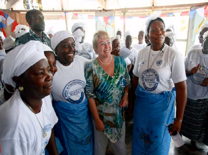 Nữ lãnh đạo Chile cười tươi chụp ảnh cùng những người phụ nữ sau khi tham dự một diễn đàn tại ngôi làng Totota, Liberia, ngày 7/3/2011. Ảnh: Flickr.