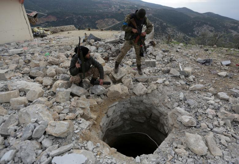 Hai chiến binh FSA đứng giữa đống đổ nát tại vùng nông thôn phía bắc Afrin ngày 16/2.