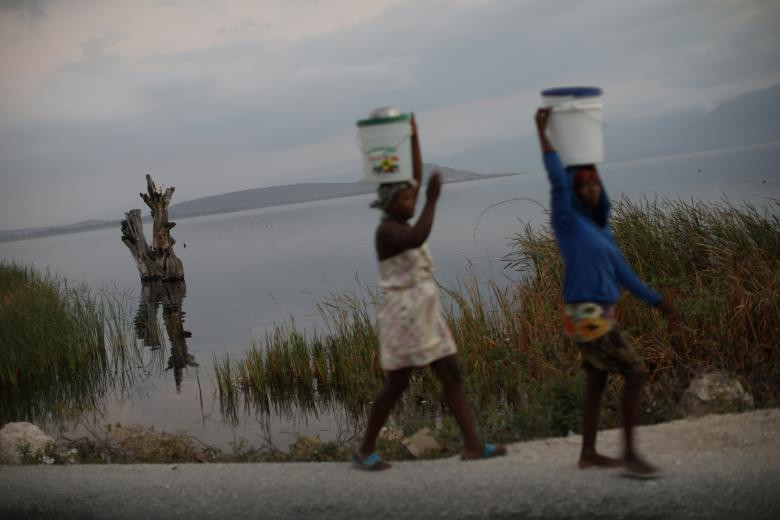 Hai người phụ nữ đi lấy nước ở ngoại ô Fond Parisien ngày 19/3.