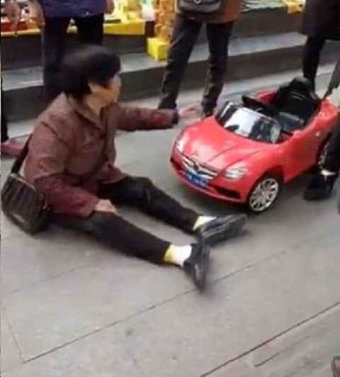 Người phụ nữ ngồi ăn vạ trên vỉa hè để đòi bồi thường. Ảnh Shanghaiist.