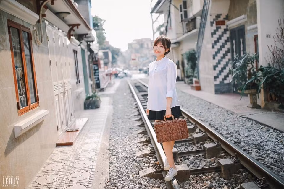 Đứng đợi tàu người ta sẽ dễ dàng liên tưởng đến khung cảnh ảm đảm, u buồn và chật chội, nhưng bộ ảnh do Mai Trang thực hiện lại được bố trí trong nền trời tươi sáng, cô mẫu cười tươi, làm dáng bên đường ray cực đáng yêu. Ảnh: Lê Huy.
