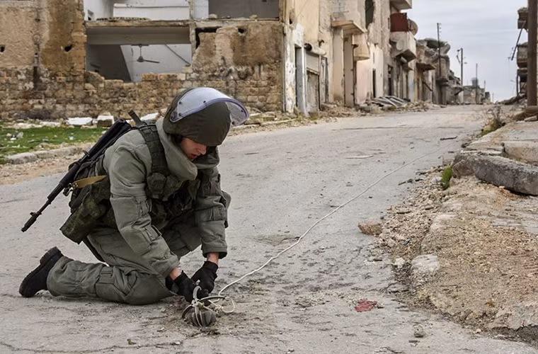 Trong ảnh là một binh sĩ công binh Nga đã cố gắng vô hiệu hóa một quả đạn cối chưa phát nổ trên một con đường ở Aleppo, nó gắm khá sâu xuống mặt đất và hoàn toàn không dễ để có thể kéo lên được. Nguồn ảnh: Bộ Quốc phòng Nga.