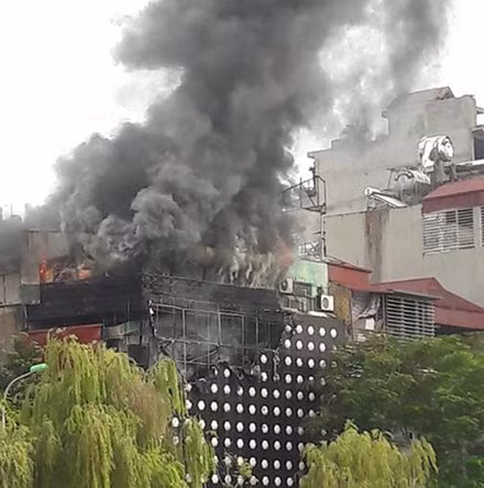 Lực lượng phòng cháy chữa cháy đã phải liên tục lấy nước sông Tô Lịch để dập tắt đám cháy. Khói đen bốc lên nghi ngút cao đến hàng chục mét, bao trùm cả con phố. Nguồn ảnh: Lao Động.