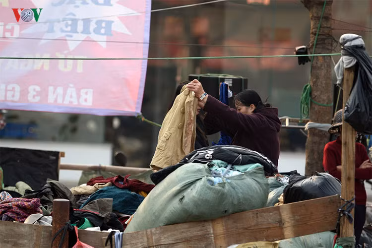 Quần áo được chất đống trong 1 “cửa hàng” quần áo rét đặt ngay trên vỉa hè quây bằng những tấm ván gỗ trên đường Kim Ngưu, quận Hoàng Mai, gần khu công nghiệp Vĩnh Hưng.