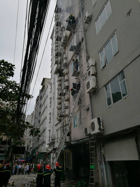 Lực lượng lính cứu hỏa đập cửa trên các tầng cao của tòa nhà để tiếp cận hiện trường vụ cháy quán karaoke trên đường Trần Thái Tông (Hà Nội). Nguồn ảnh: Infonet.