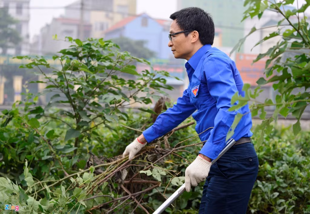 Phó thủ tướng Vũ Đức Đam cầm cuốc và dao dọn dẹp nhiều ngóc ngách quanh hồ Linh Đàm.