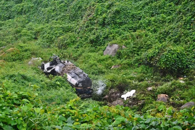 Vụ tai nạn khiến phần đầu xe bị đâm vỡ nát, lái xe văng ra ngoài tử vong tại chỗ, một người khác bị thương nặng đi cấp cứu. Hình ảnh chiếc xe nằm bẹp dúm dưới vực. Nguồn ảnh: FB.
