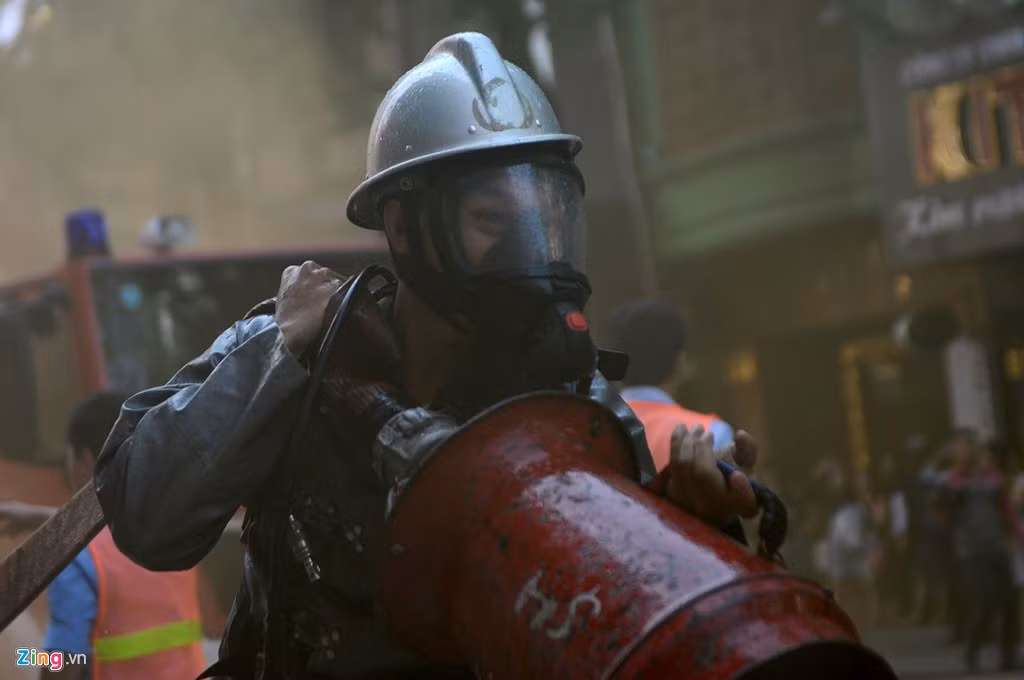 Các chiến sĩ nhanh chóng kéo vòi nước từ xe chữa cháy tiếp cận hầm giữ xe, nơi đang cháy dữ dội.