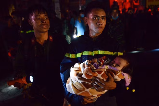Người chiến sĩ bế trên tay một em nhỏ trong vụ cháy chung cư Xa La (Hà Đông).