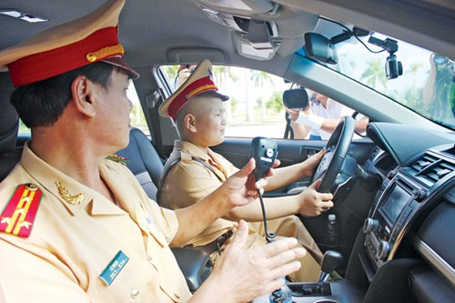 Bé Dũng cùng đại tá Lê Ngọc (Trưởng phòng CSGT Công an Đà Nẵng) trên xe tuần tra. Nguồn ảnh: Tiền Phong.