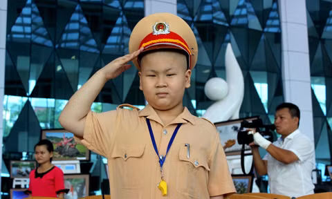 Biết được điều đó, bác sĩ Lê Na của Bệnh viện Ung bướu Đà Nẵng đã viết tâm thư gửi đến lãnh đạo công an Đà Nẵng. Bức thư cảm động của bác sỹ và ước mơ đáng yêu của cậu bé đã được các chiến sĩ CSGT Đà Nẵng biến thành hiện thực trong ngày sinh nhật thứ 11 của Dũng (21/11/2015). Ảnh cậu bé "cảnh sát giao thông" chào điều lệnh. Nguồn ảnh: Công an.