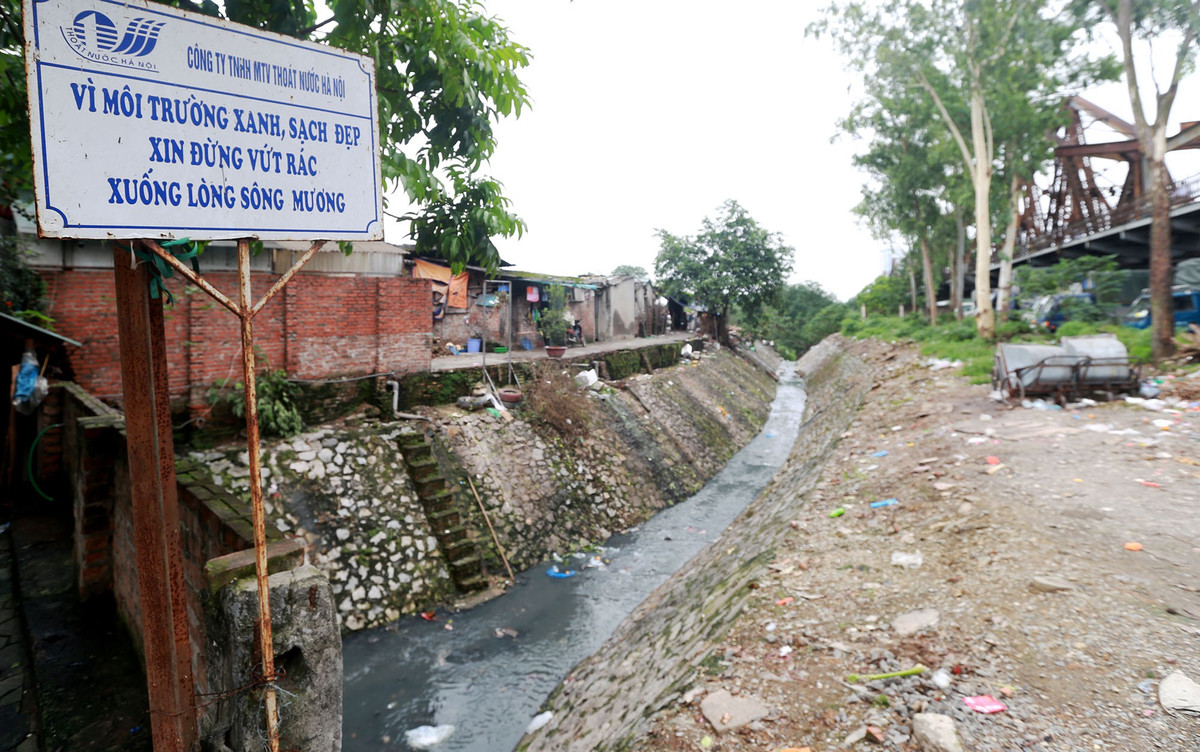 Mặc dù ngay phía trên, tấm biển "Vì môi trường xanh, sạch đẹp, xin đừng vứt rác xuống lòng sông mương" được treo ngay ngắn. 