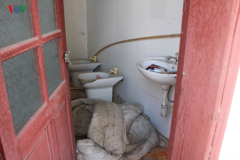 Một nhà vệ sinh có nhiều thiết bị hỏng, nằm ngổn ngang.