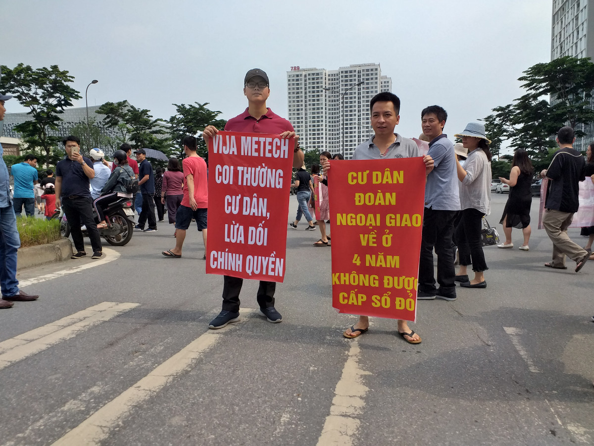 Một cư dân căng băng rôn bày tỏ bức xúc về vấn đề sổ đỏ.