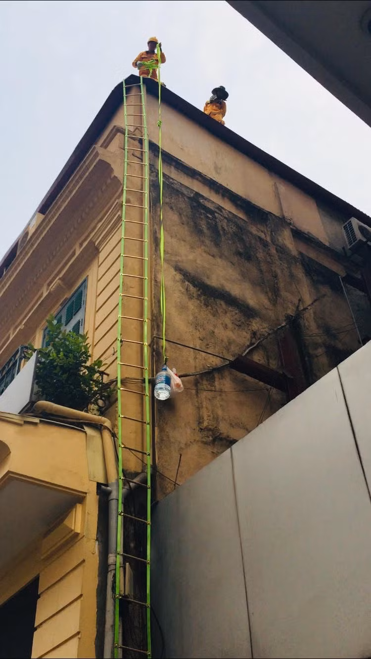 Để giảm nhiệt cái nắng, bình nước cùng chút hoa quả được các anh leo dây lên.